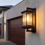 Fluted glass outdoor wall lantern beside a garage door at dusk