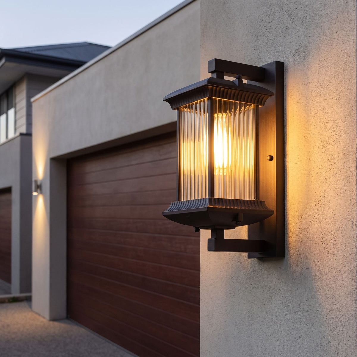 Fluted glass outdoor wall lantern beside a garage door at dusk