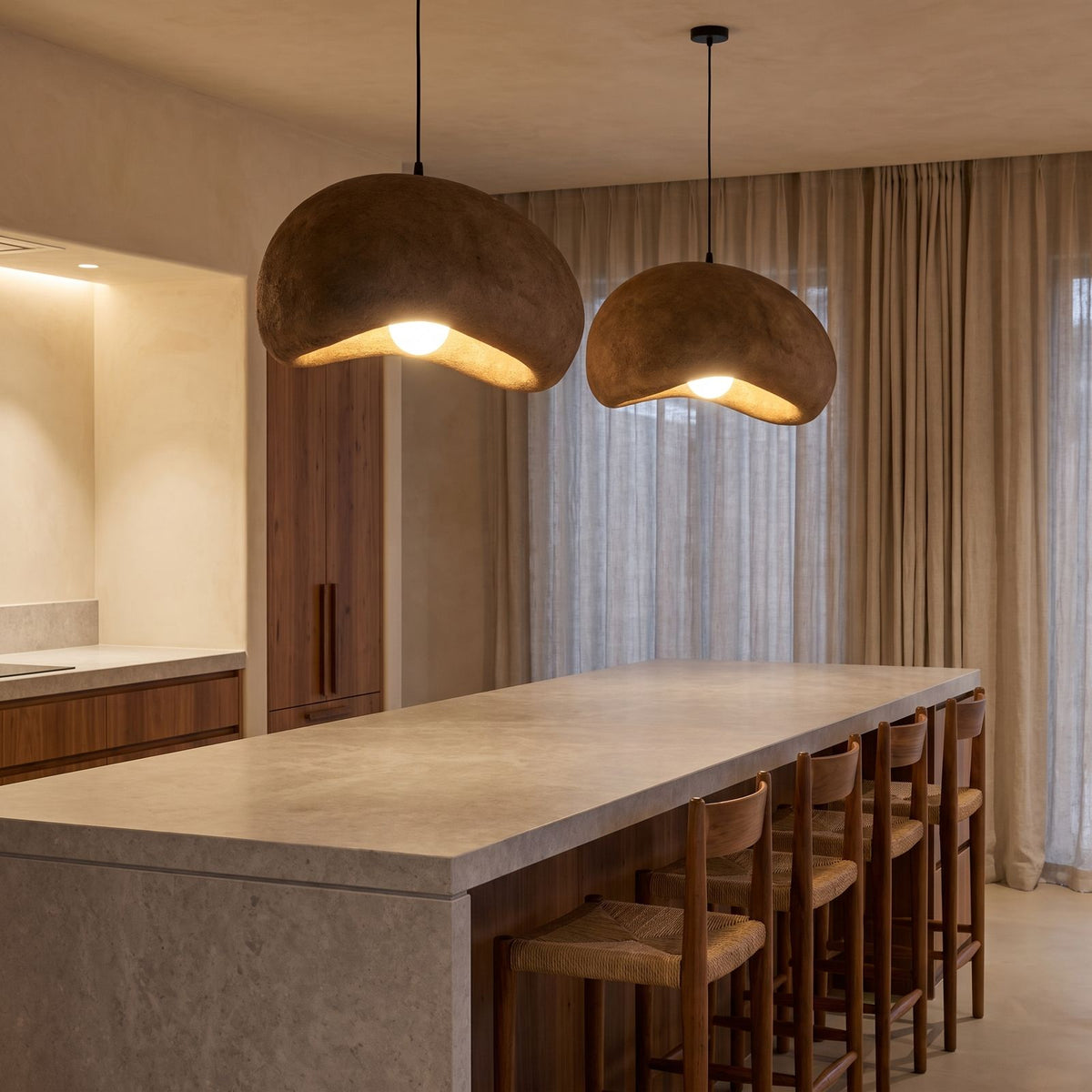A pair of Coffee Brown Textured Resin Cloud Pendant Lights over a stone kitchen island