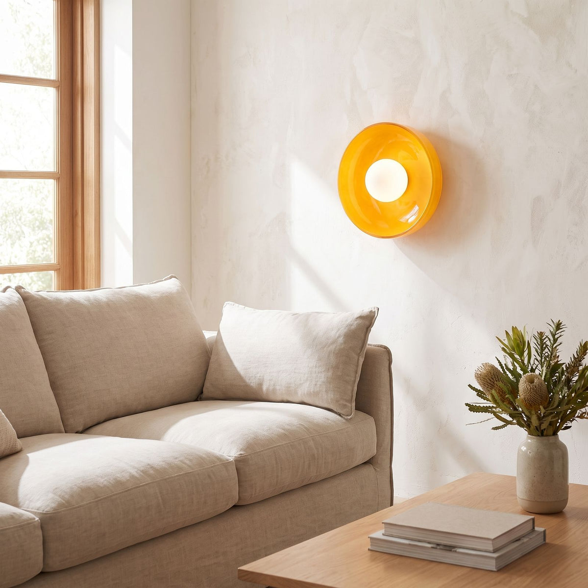 Coloured glass dish wall and ceiling light beside a living room sofa in daylight