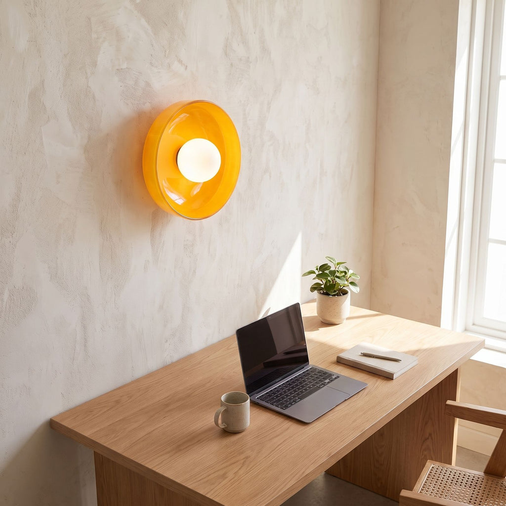 Coloured glass dish wall and ceiling light above a home office desk in daylight