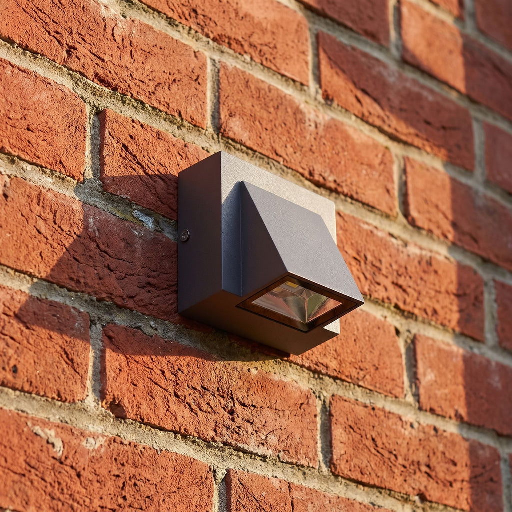 Compact Metal LED Outdoor Wall Light, close view at 45 degrees on a stone wall