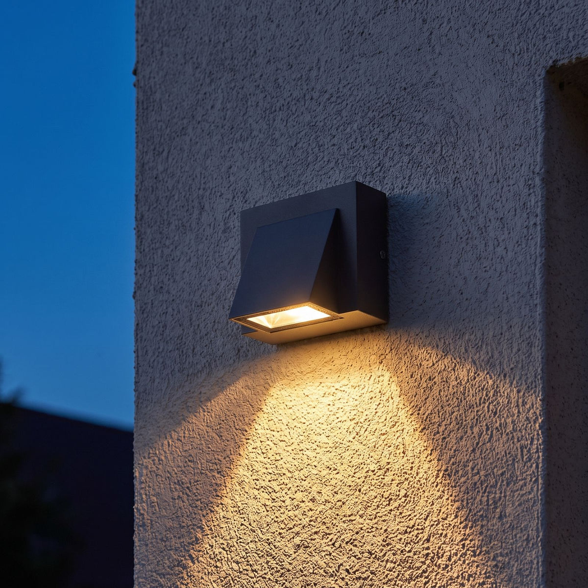 Compact Metal LED Outdoor Wall Light on a porch wall at dusk