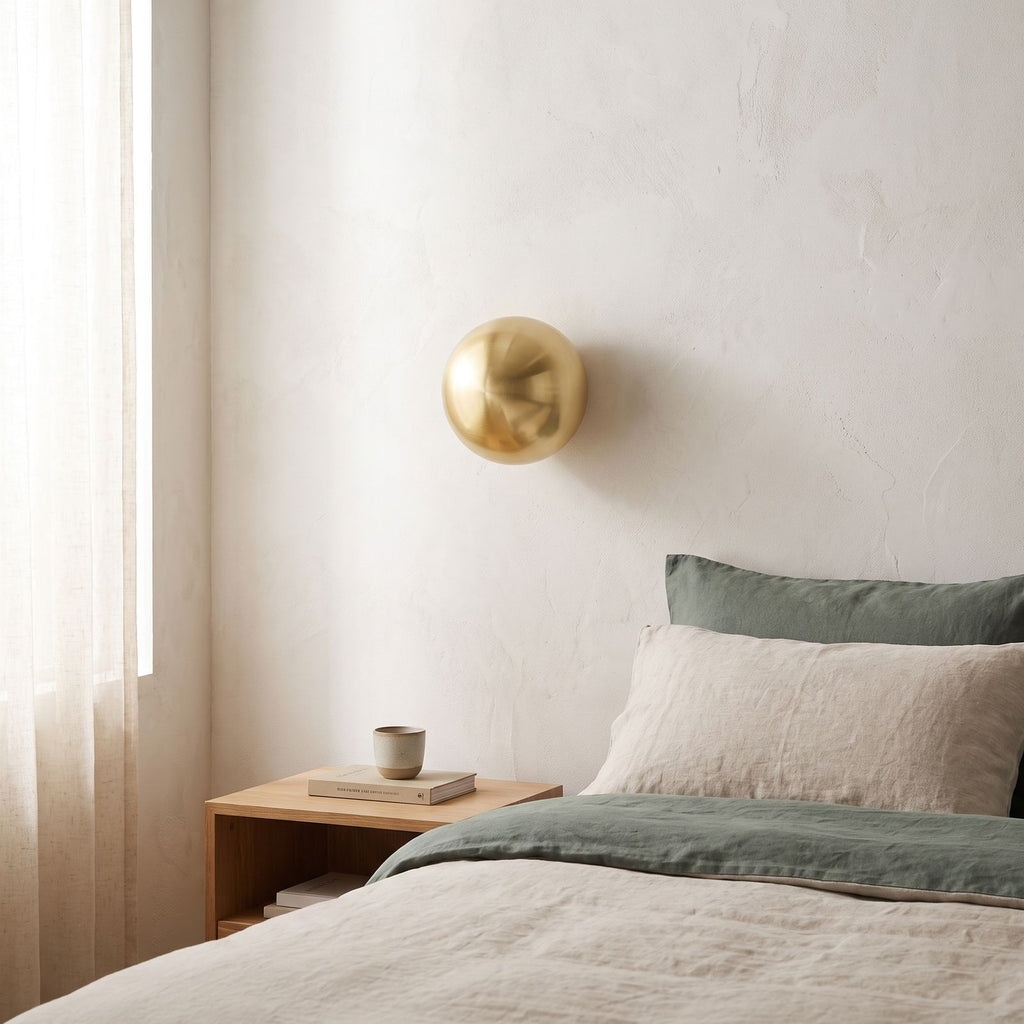 Compact Round Iron LED Wall Light on a bedroom wall beside the bed