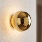 Compact Round Iron LED Wall Light, close view at 45 degrees on a plaster wall