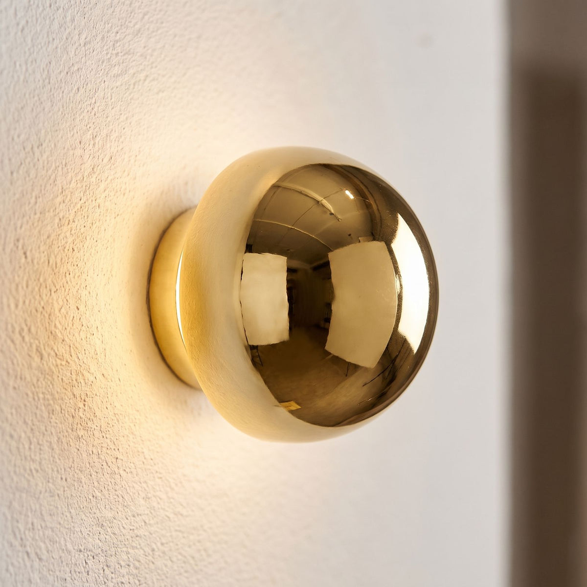 Compact Round Iron LED Wall Light, close view at 45 degrees on a plaster wall