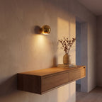 Compact Round Iron LED Wall Light in a hallway above a timber console