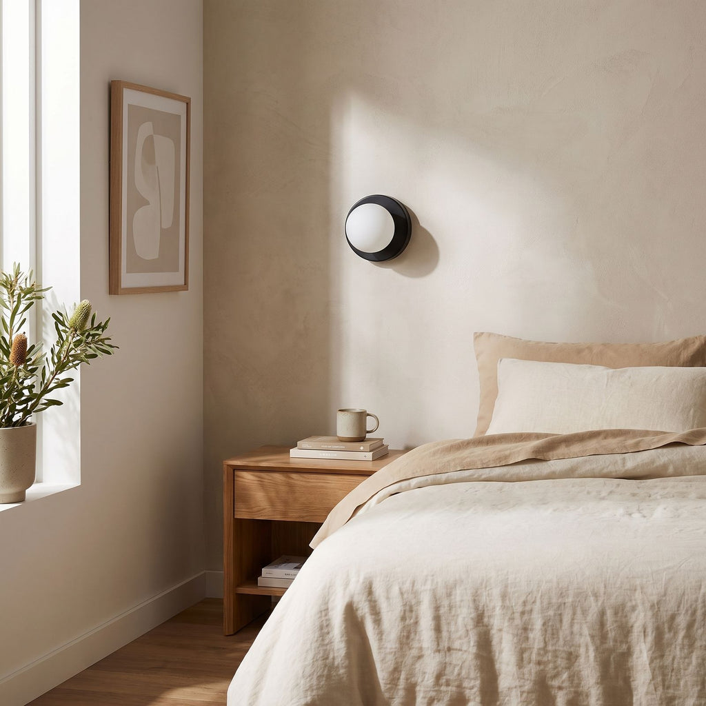 Compact Rounded Glass and Iron Wall Light on a bedroom wall beside the bed