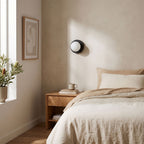 Compact Rounded Glass and Iron Wall Light on a bedroom wall beside the bed