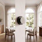 Compact Rounded Glass and Iron Wall Light on a dining room wall