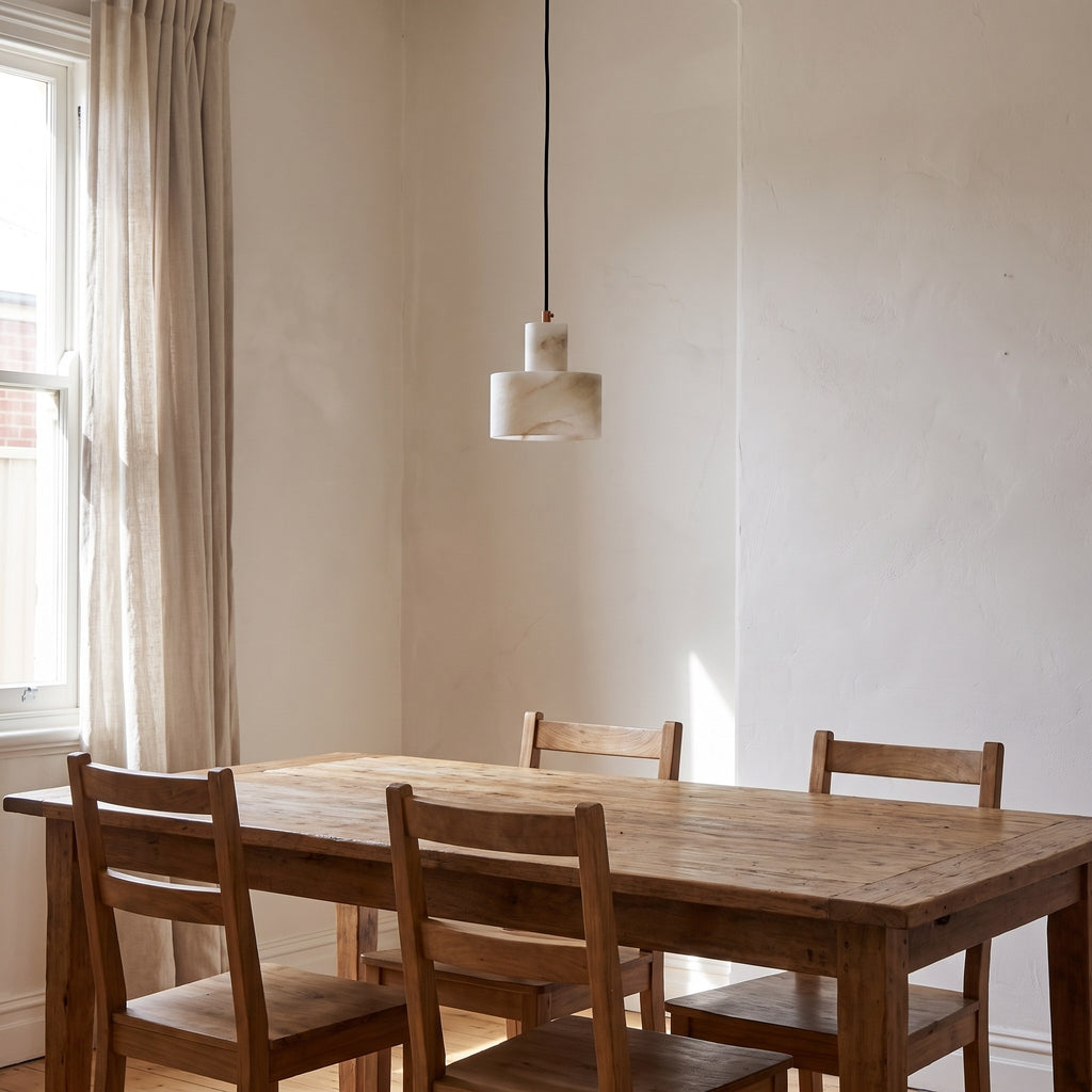 Copper and Alabaster Cylinder Pendant Light above a timber dining table in daylight