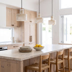 Three Copper and Alabaster Cylinder Pendant Lights above a stone kitchen island