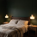 A pair of Copper and Alabaster Cylinder Pendant Lights beside a bed