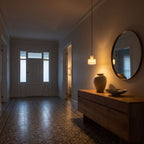 Copper and Alabaster Cylinder Pendant Light above a timber console in an entry hallway in the evening