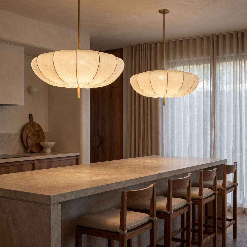 A pair of Cream Fabric Wabi Sabi Pendant Lights over a stone kitchen island
