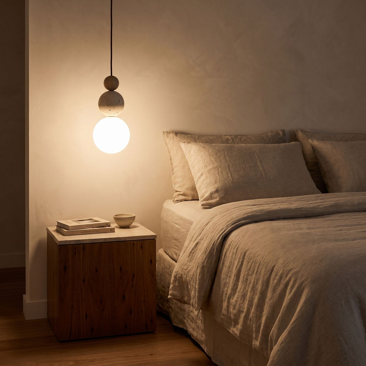Cream Stone Ball Bedside Pendant Light hanging beside a bed