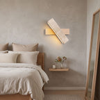 Crossed Travertine and Wood Rotating Wall Light on a bedroom wall beside the bed
