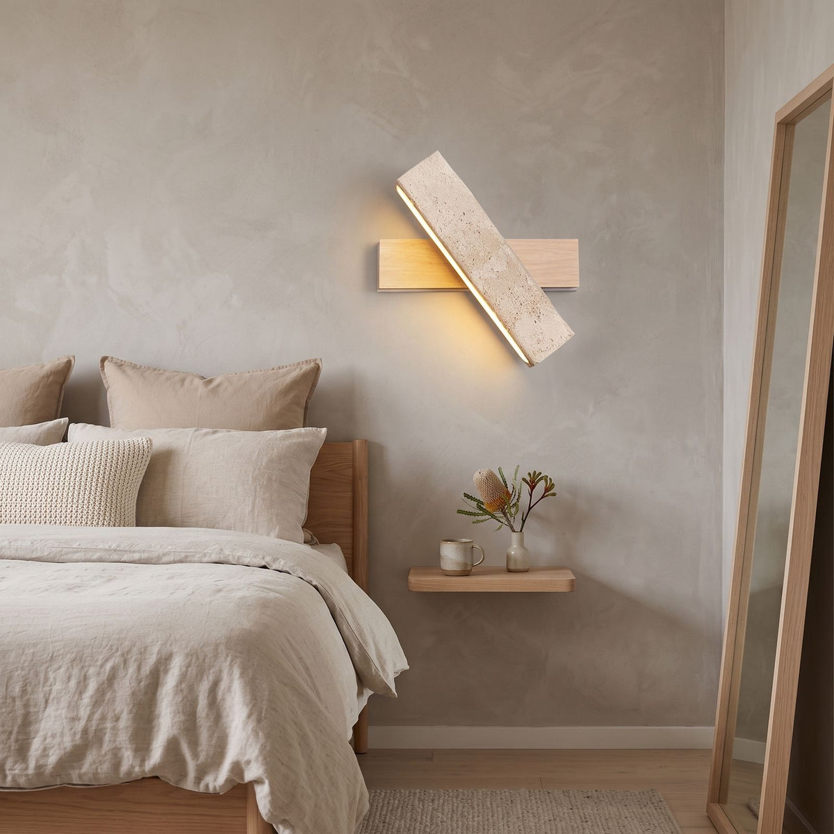 Crossed Travertine and Wood Rotating Wall Light on a bedroom wall beside the bed