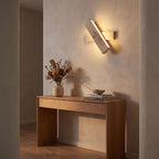 Crossed Travertine and Wood Rotating Wall Light in a hallway above a timber console