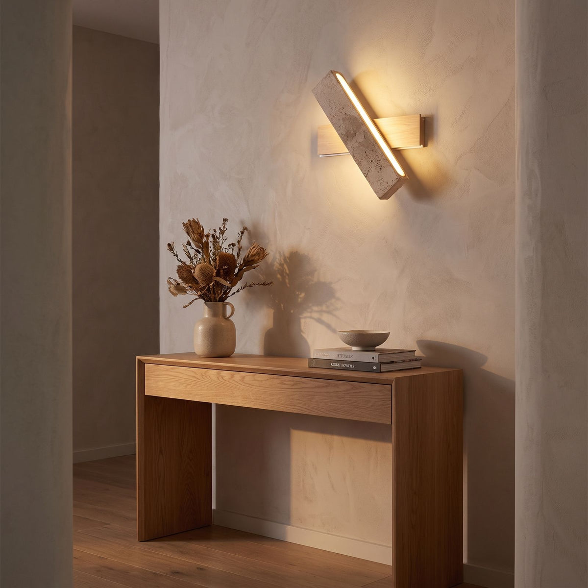 Crossed Travertine and Wood Rotating Wall Light in a hallway above a timber console