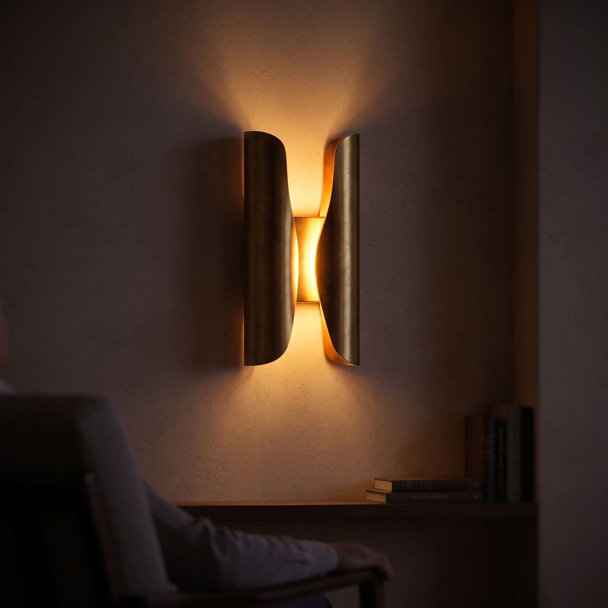 Curled Brass Panel Wall Sconce glowing on a plaster wall at night