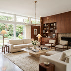 Curved Arm Antique Gold Iron Candle Chandelier above a coffee table in a living room in daylight