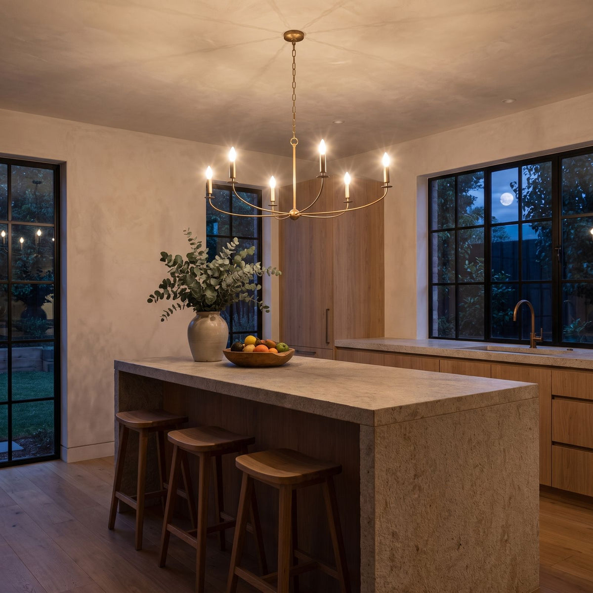 Curved Arm Antique Gold Iron Candle Chandelier above a kitchen island at night