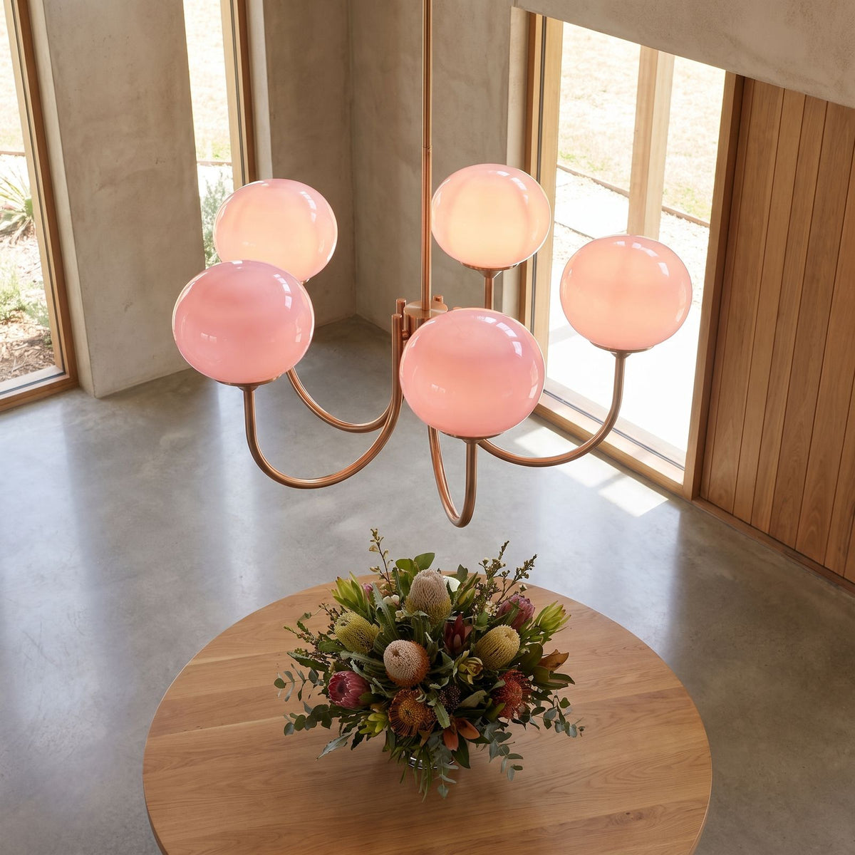 Curved arm opal glass globe chandelier in an entry hall in daylight