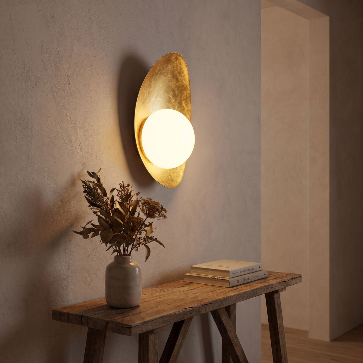 Curved Gold Shield Opal Globe Wall Light in a hallway above a timber console