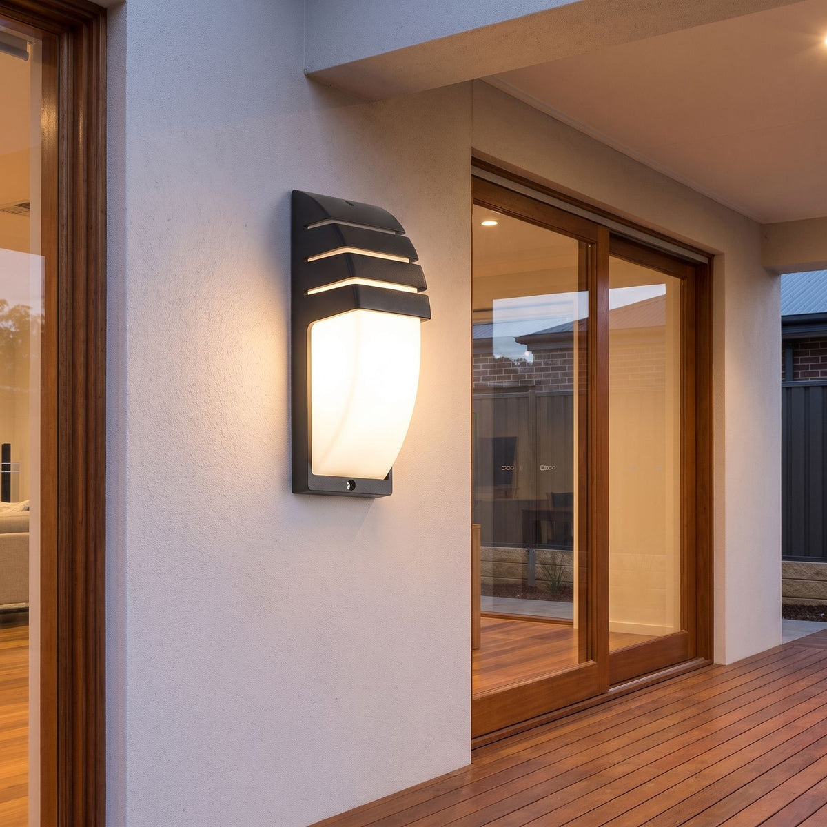 Curved louvred sensor outdoor wall light on a covered alfresco patio wall