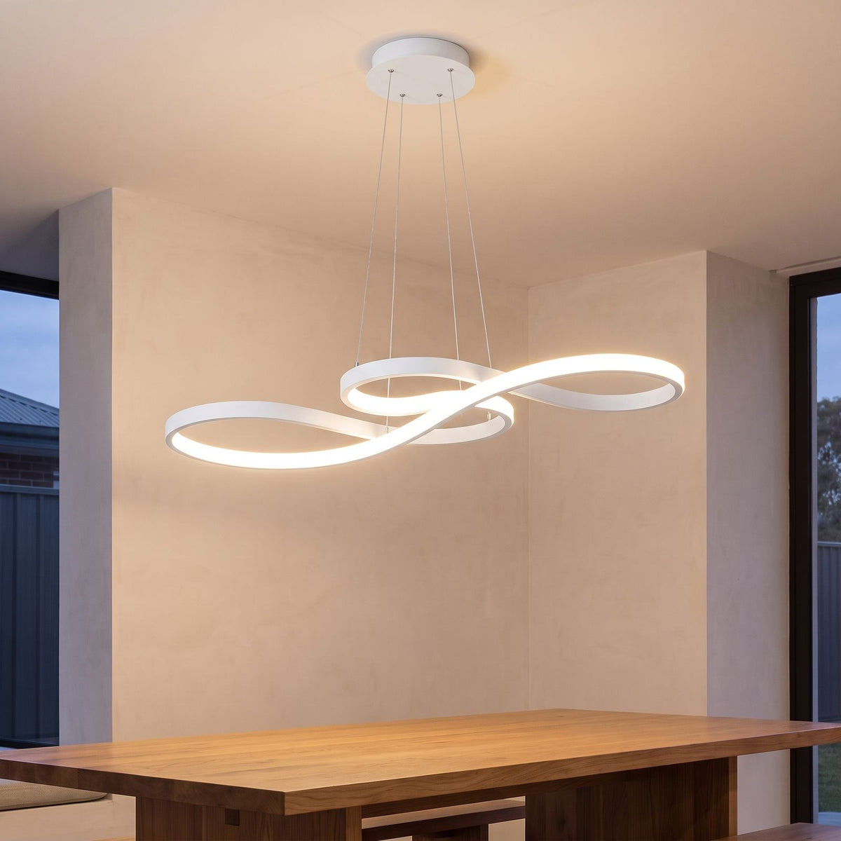 Curved Ribbon Aluminium LED Pendant Light in white above a dining table