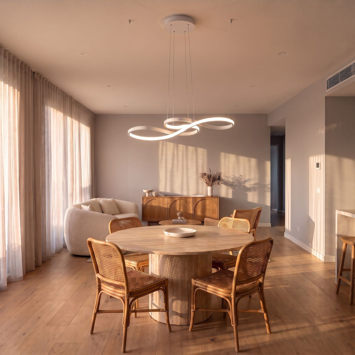 White Curved Ribbon Aluminium LED Pendant Light in neutral white above a round dining table in a living and dining area with a sofa