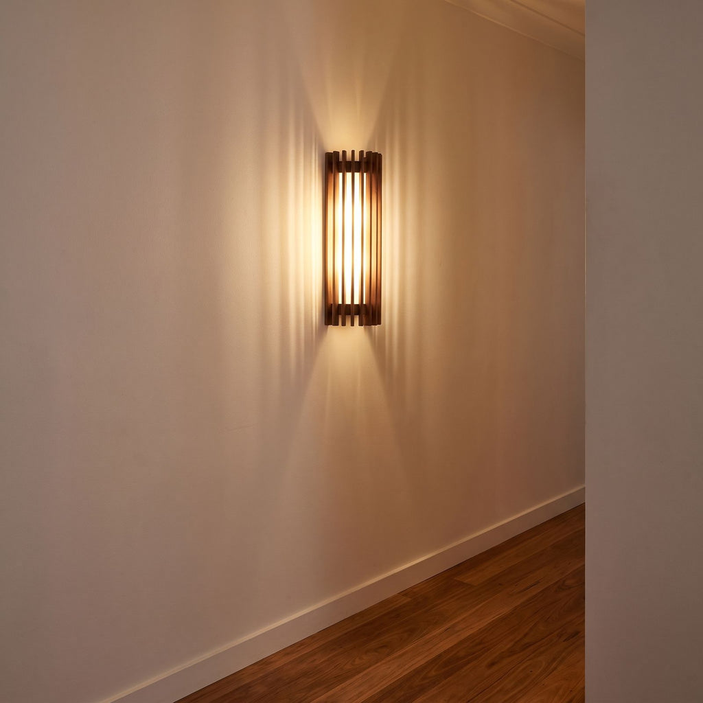 Curved slatted wood wall sconce on a hallway wall