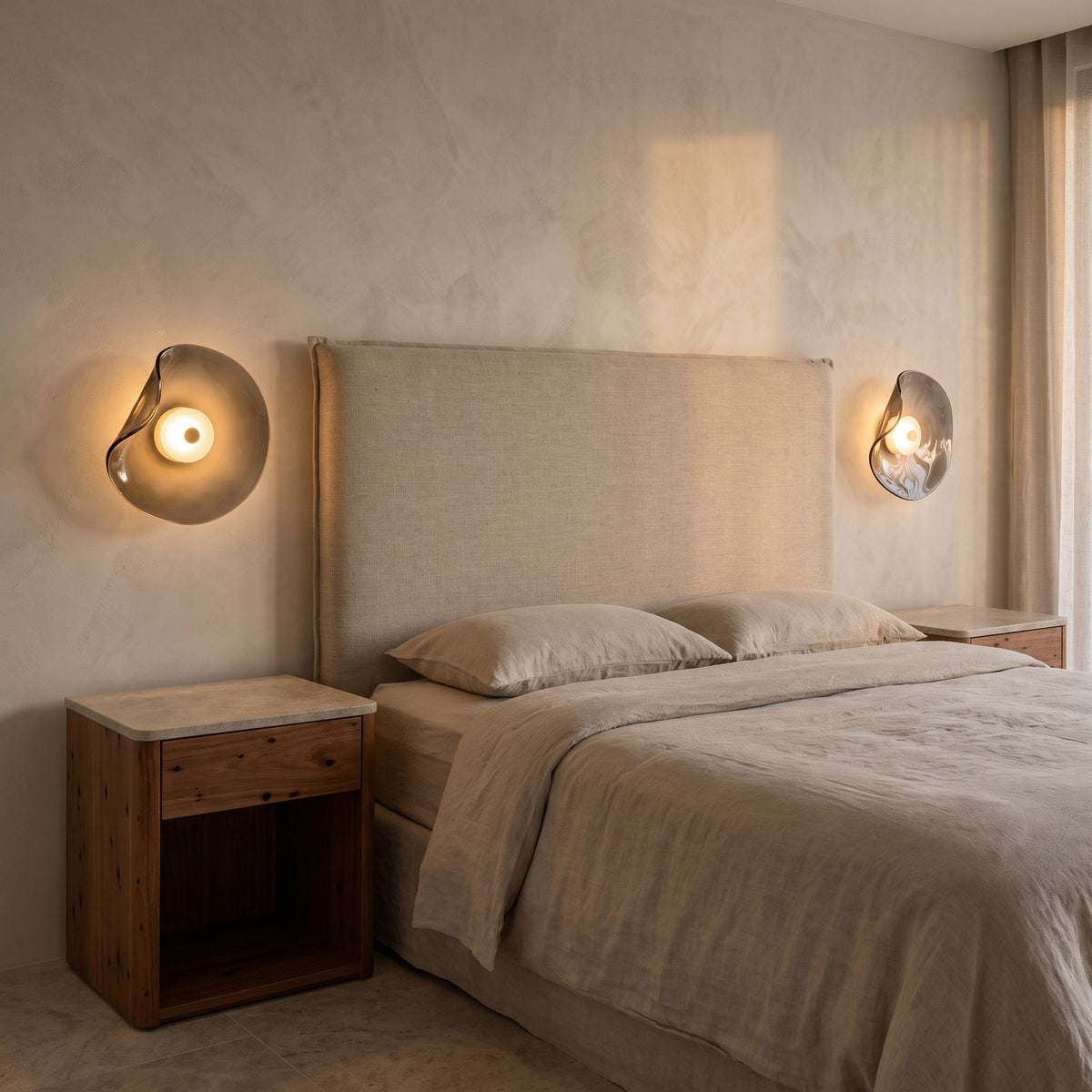 A pair of Curved Smoke Glass Up Down Wall Lights either side of a bed headboard