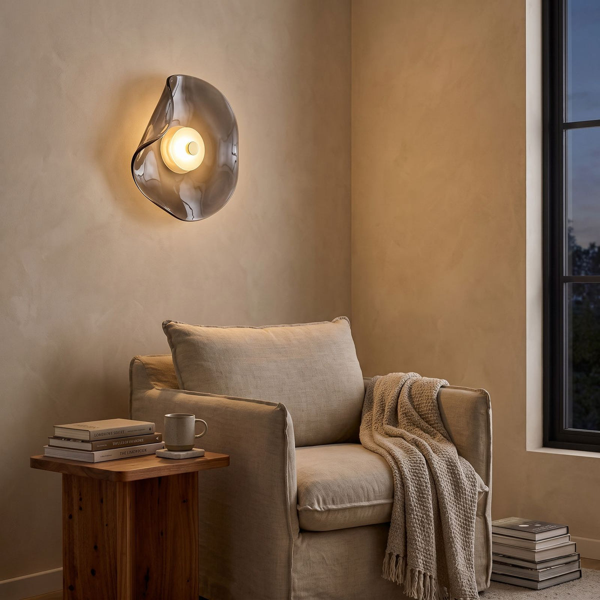 Curved Smoke Glass Up Down Wall Light above an armchair in a reading corner
