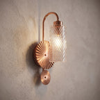 Diagonal Fluted Glass Cylinder Wall Light, close view at 45 degrees on a plaster wall
