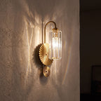Diagonal Fluted Glass Cylinder Wall Light glowing on a plaster wall at night