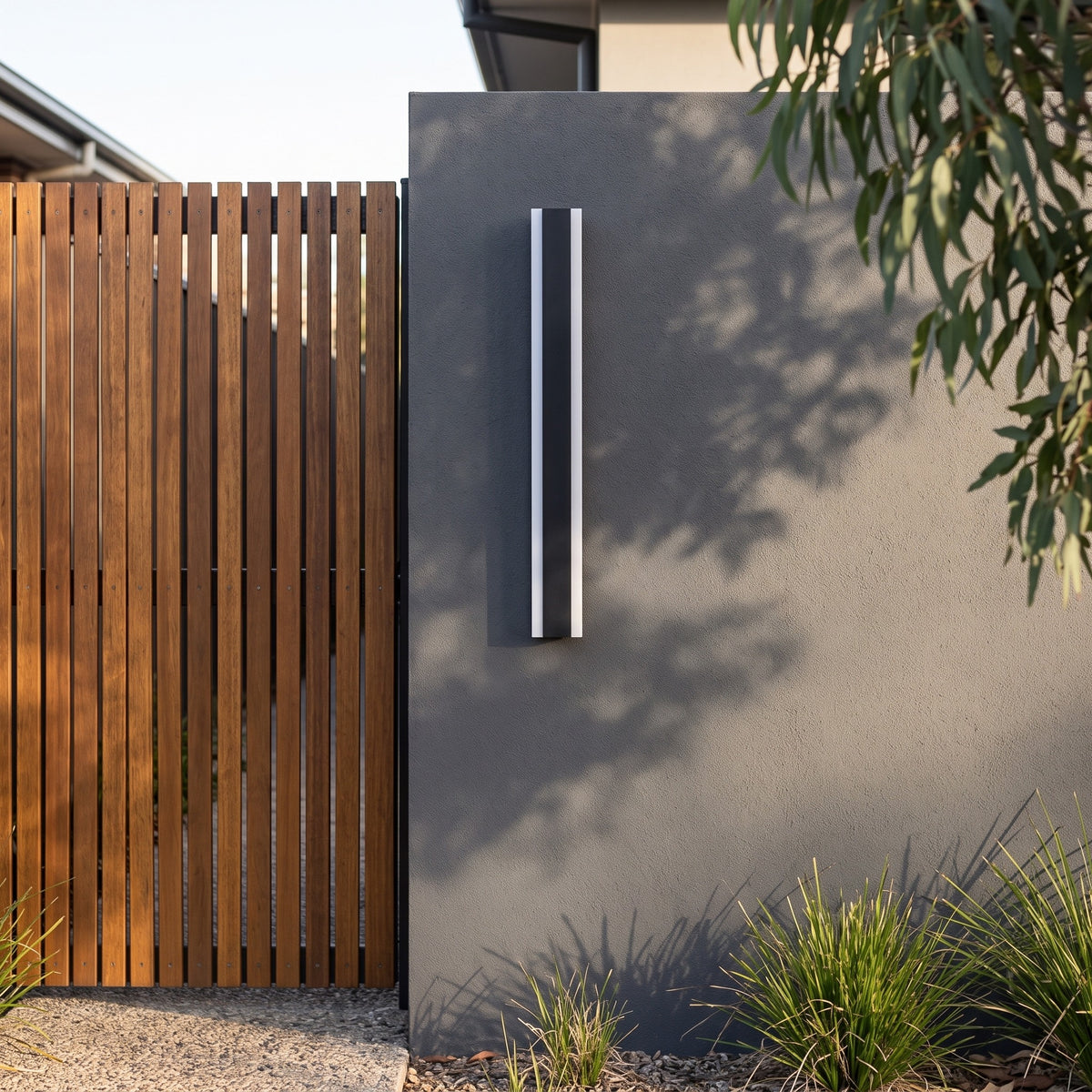 Black linear outdoor wall light on a charcoal rendered wall next to a timber slat side gate