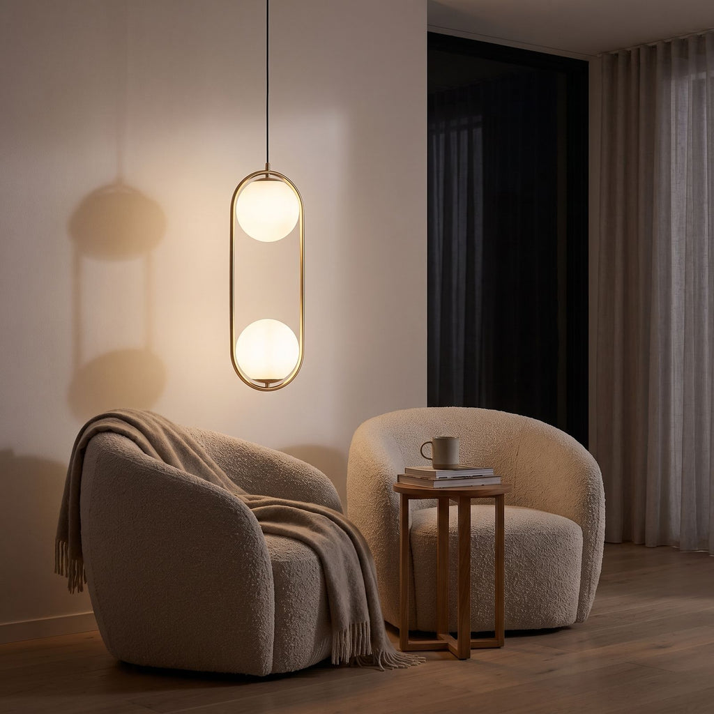 Double glass globe oval hoop pendant light over a reading armchair at night