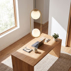 Double glass globe oval hoop pendant light above a home office desk in daylight