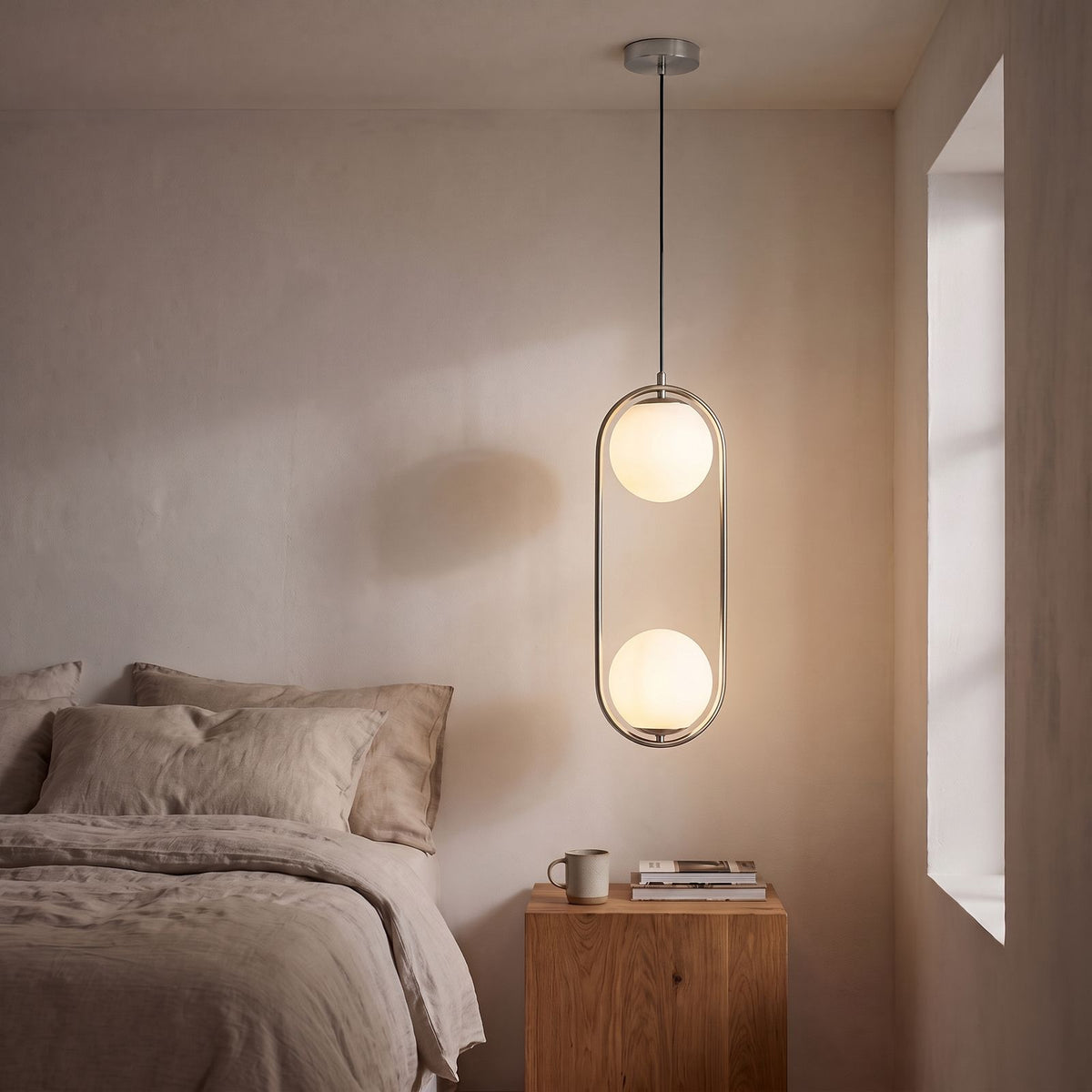 Double Frosted Glass Globe Oval Hoop Pendant Light in chrome beside a bed