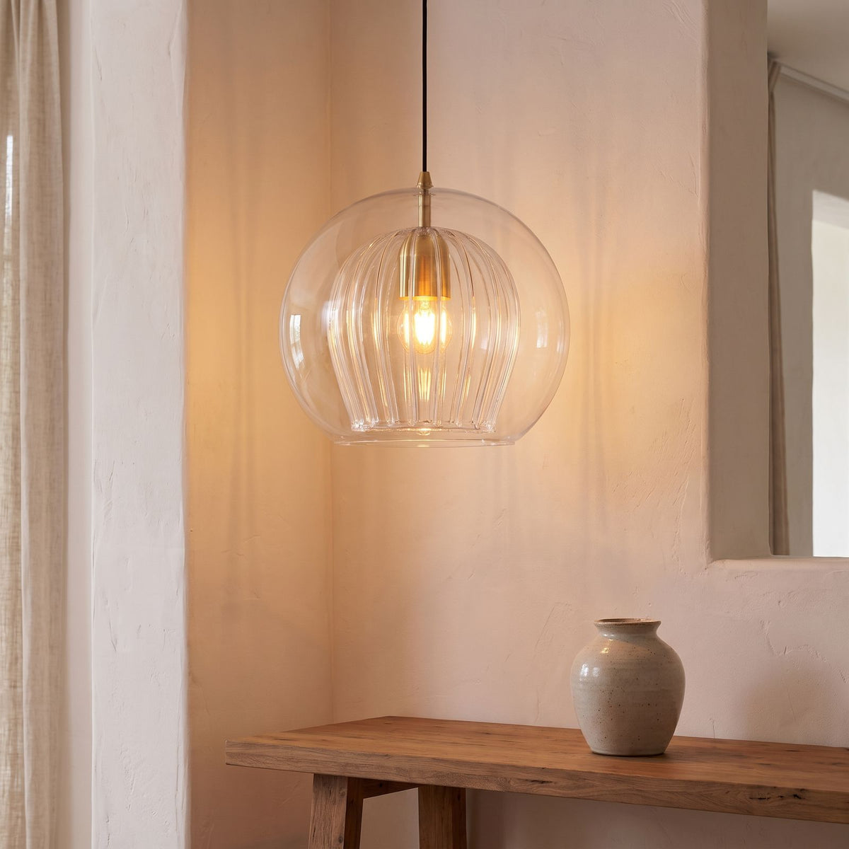 Double glass fluted dome pendant light above an entry hall console