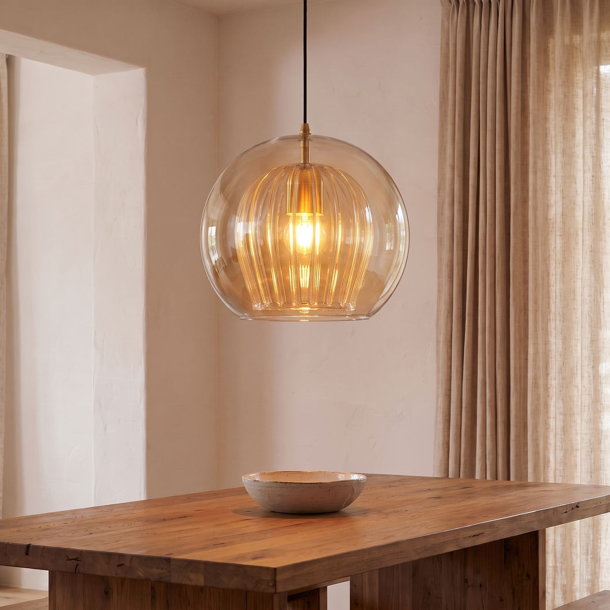 Double Glass Fluted Dome Pendant Light in amber glass above a dining table