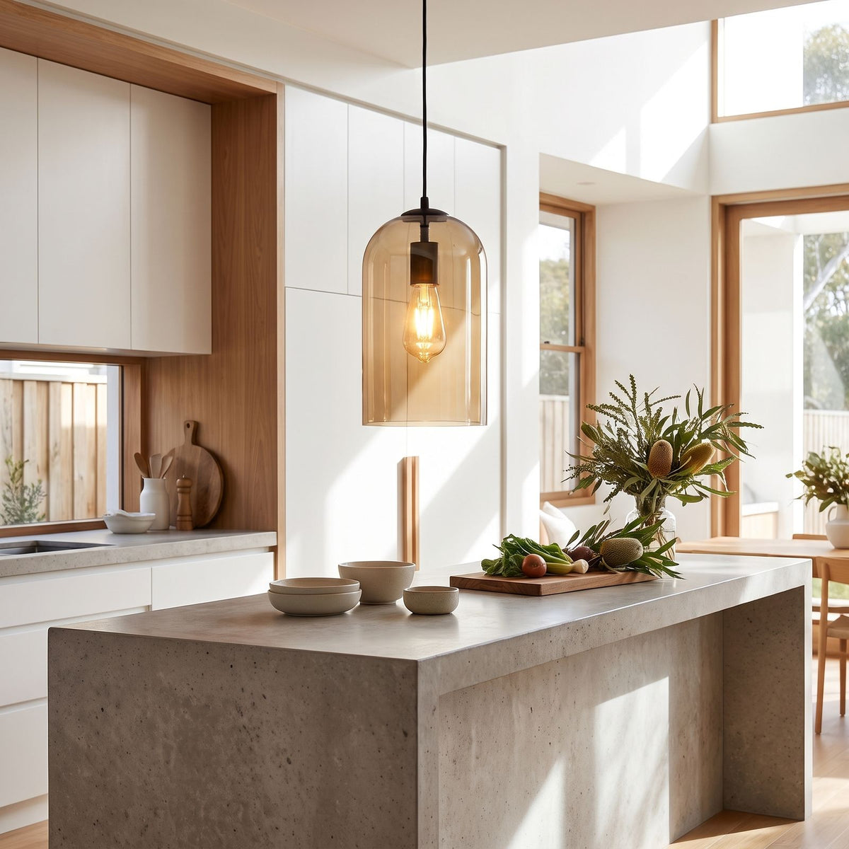 Double layer tinted glass bell pendant light over a kitchen island in daylight
