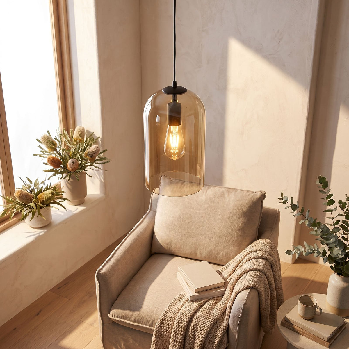 Double layer tinted glass bell pendant light over a reading armchair in daylight