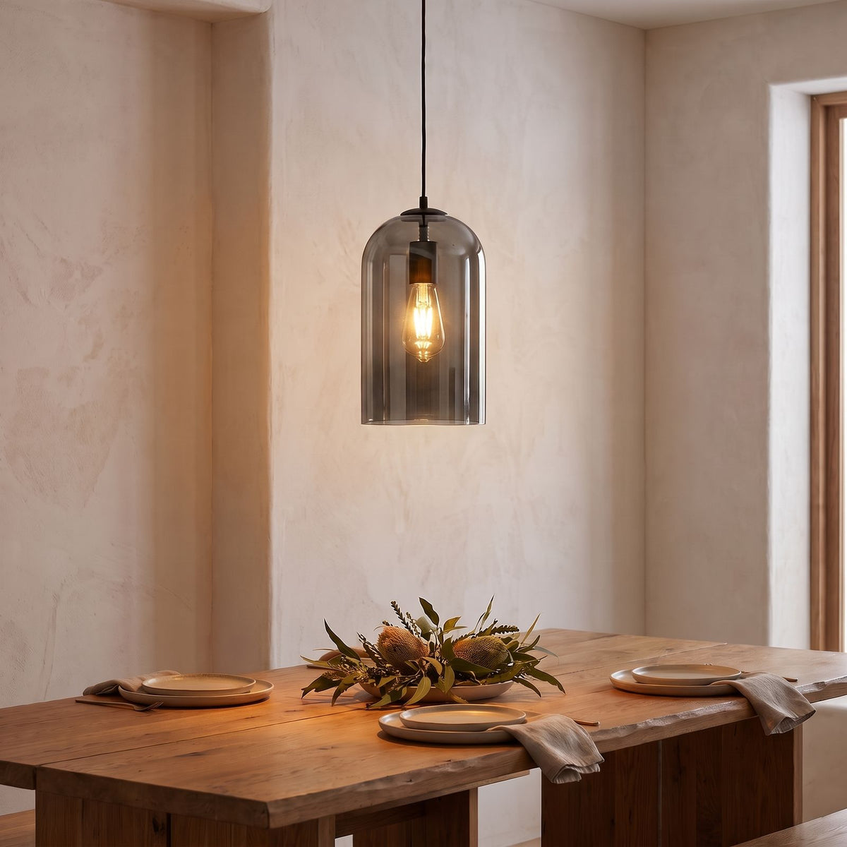 Double Layer Tinted Glass Bell Pendant Light in smoky black glass above a dining table