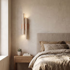 Double Travertine Column Wall Light on a bedroom wall beside the bed
