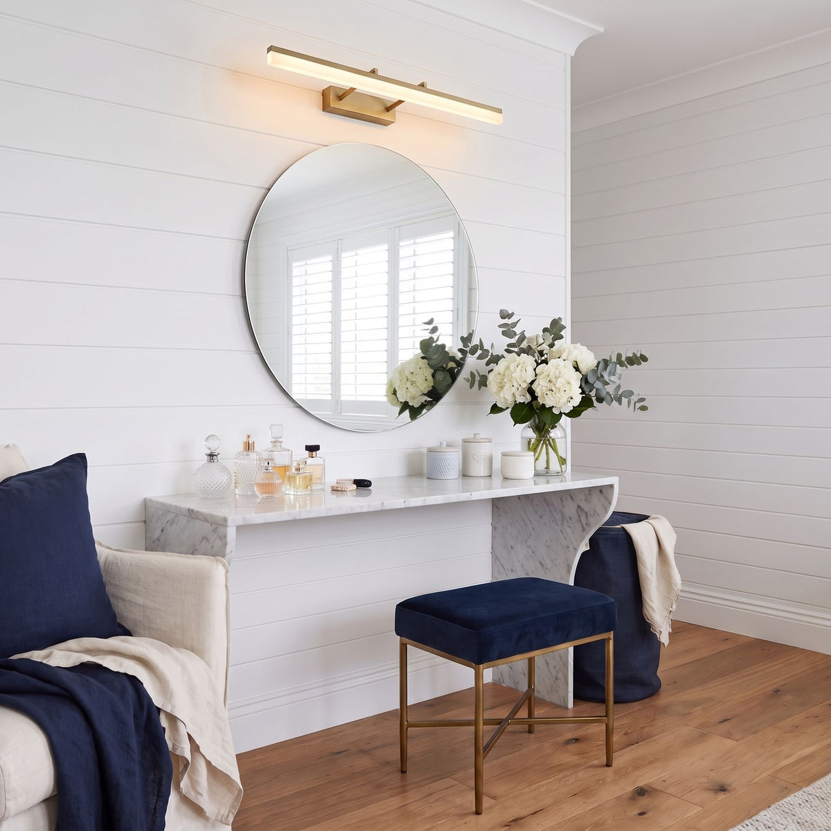 Extendable Dual Rod Stainless Steel LED Vanity Wall Light in gold, above the mirror of a dressing table