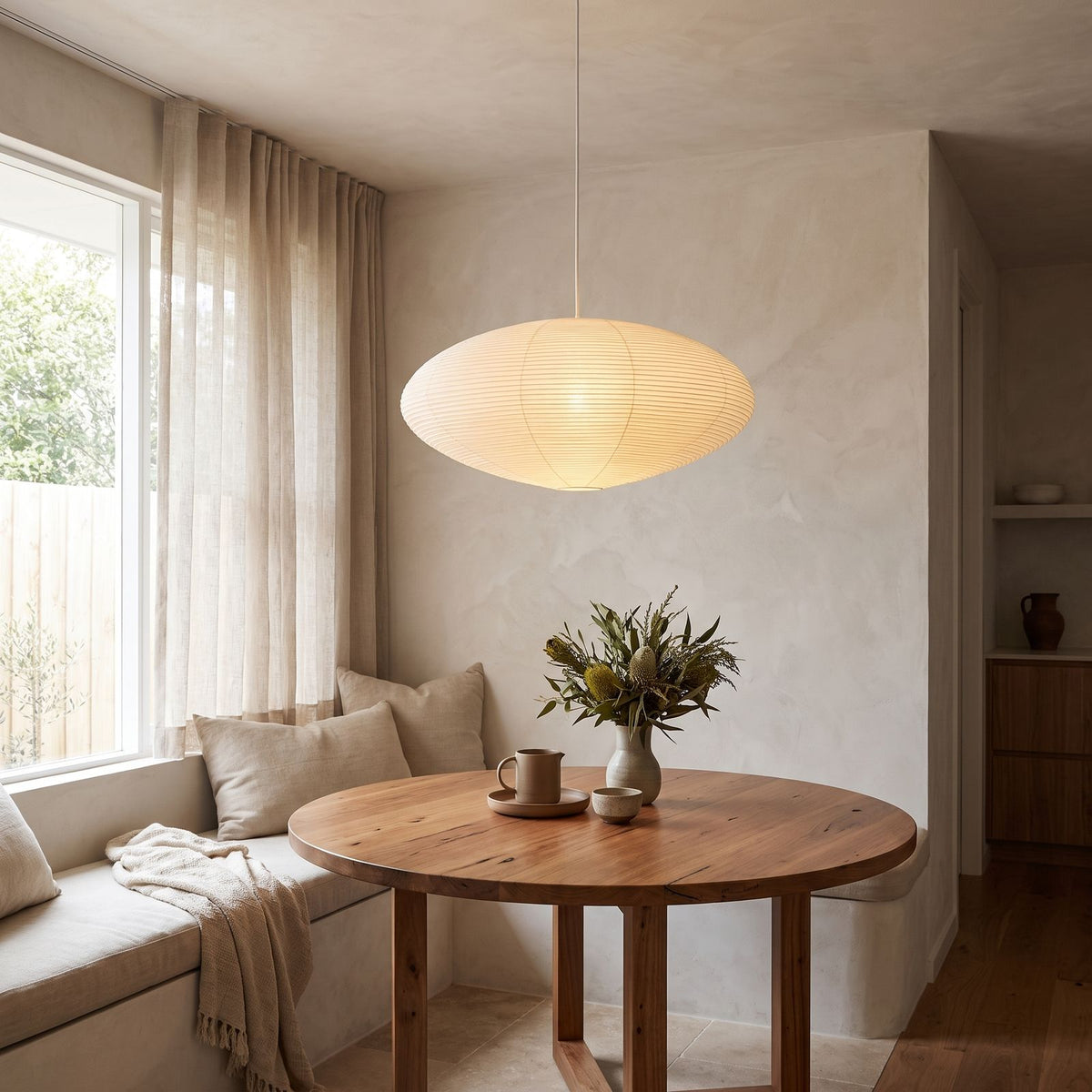 Faceted Mulberry Paper Pendant Light above a round table in a breakfast nook