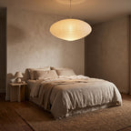 Faceted Mulberry Paper Pendant Light centred above a bed